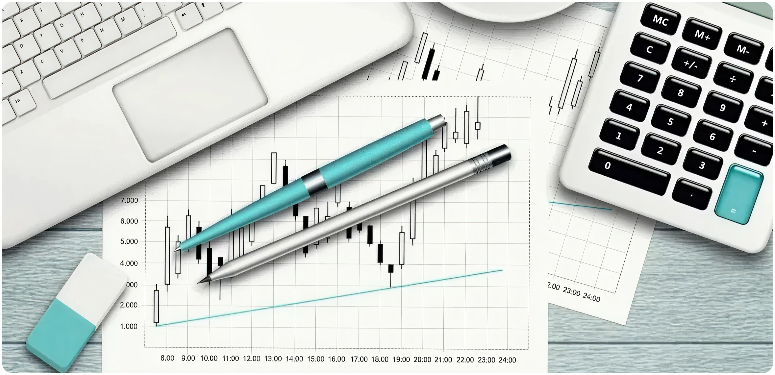 Laptop, pens, and financial charts on desk
