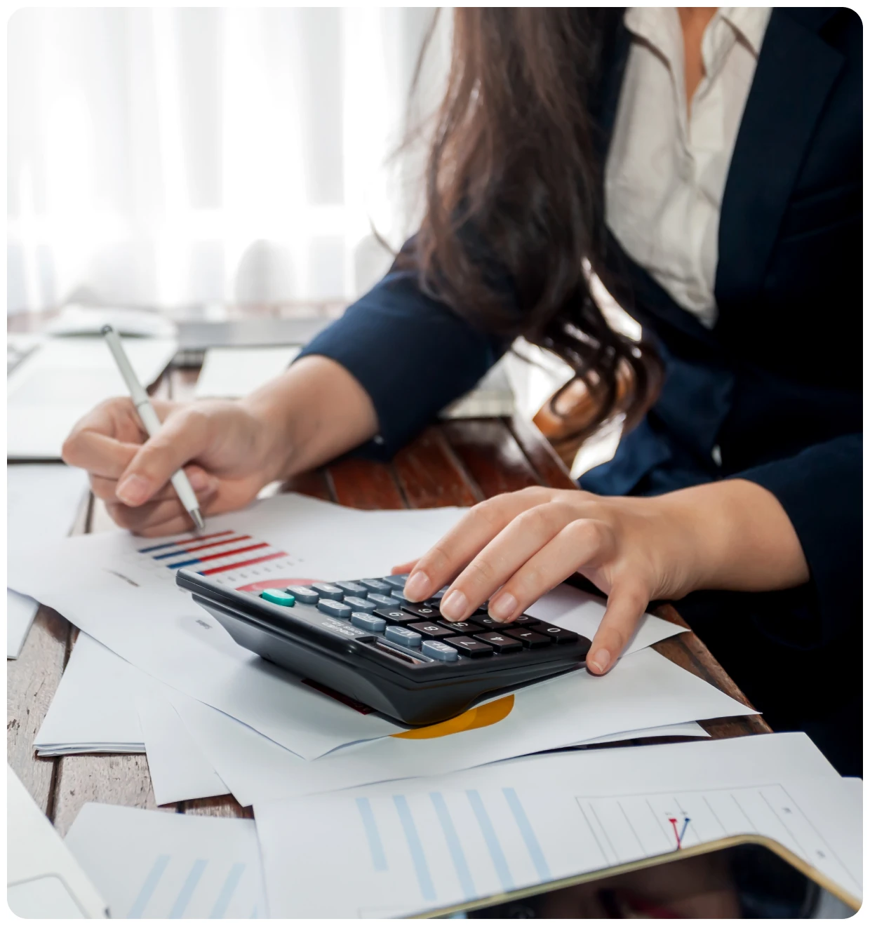 Person using calculator and reviewing documents.